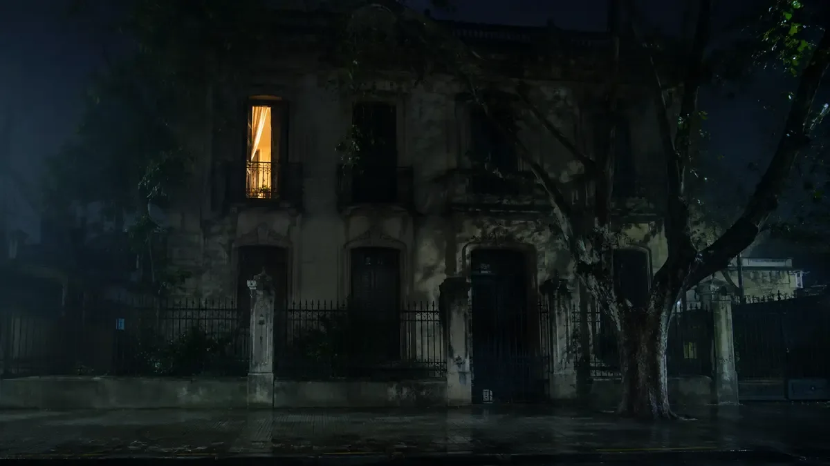 Casas embrujadas de Buenos Aires: fachada de casona antigua de noche con una única ventana iluminada y la cortina corrida
