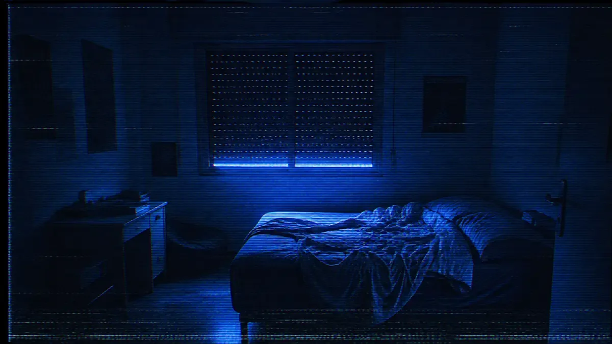 Cuarto juvenil a oscuras iluminado únicamente por el resplandor azul de una pantalla