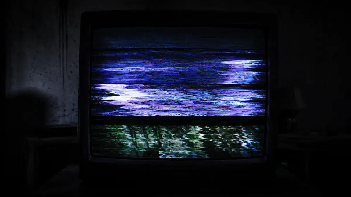 Creepypastas y leyendas de internet: pantalla CRT en primer plano con bandas horizontales de tracking y colores desangrados