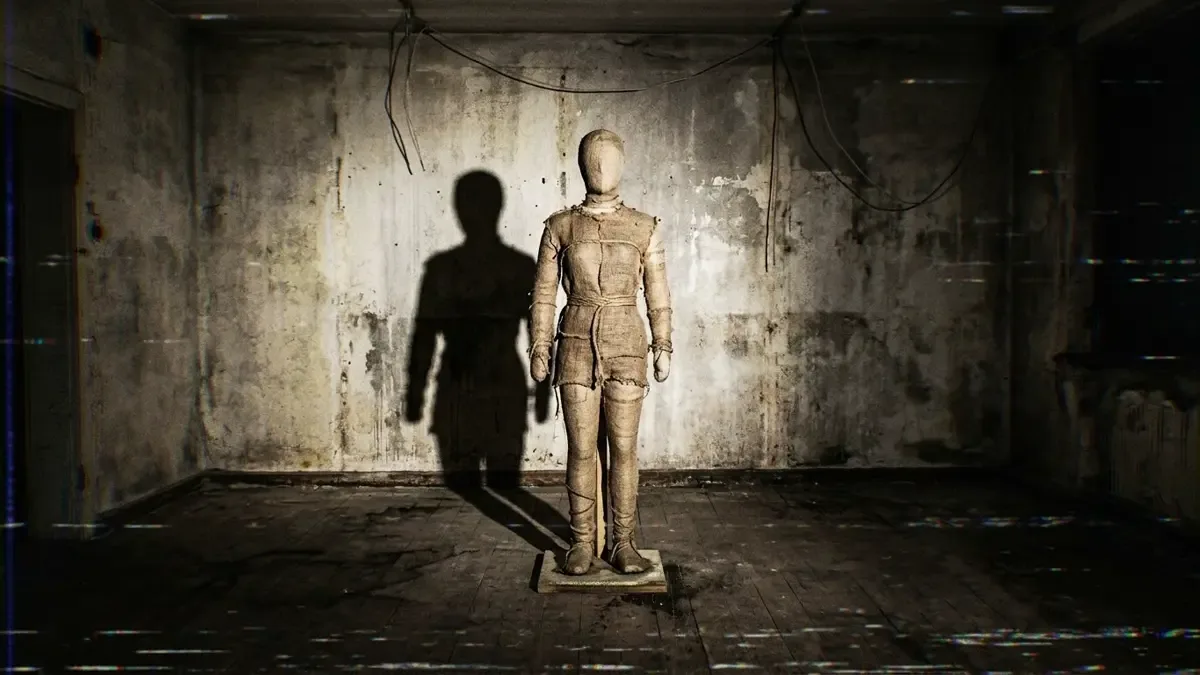 Maniquí de tela sin rasgos parado en el centro de una sala completamente vacía